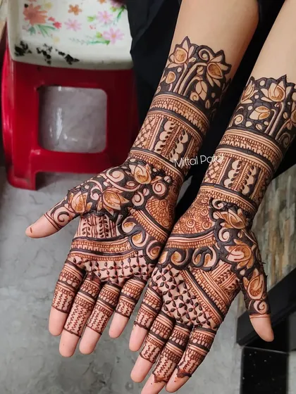 A beautiful Indian mehndi design with a mix of floral and traditional patterns. The use of bold lines and delicate fills creates a balanced and eye-catching look.