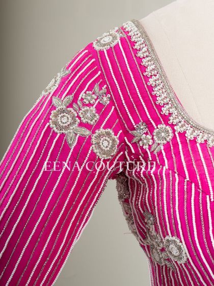 Pretty in pink, this raw silk blouse features intricate pearl and silver thread work in a striped pattern. I added floral motifs and delicate danglers on the sleeves for a touch of playful elegance.