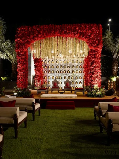This is where vows are exchanged and forevers begin. We designed this breathtaking 'Ruby Romance' mandap with a dense arch of red roses and a curtain of golden kaleeras, creating an opulent and unforgettable ceremonial space.