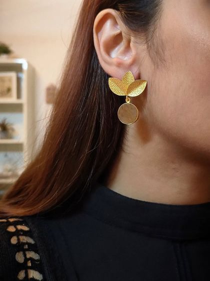 A side profile shot of me wearing the gold-plated floral stud with a dangling disc, a perfect example of minimal yet elegant design.
