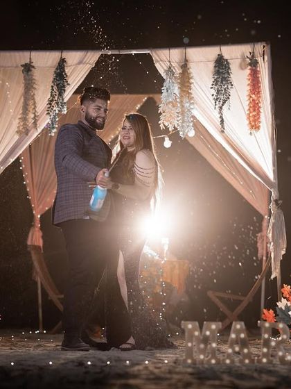 A backlit shot of the couple in their romantic beach setup, creating a dreamy and dramatic silhouette effect for their pre-wedding album.