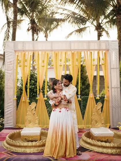 A beautiful portrait of the couple at their Haldi ceremony. The vibrant yellow decor and their coordinated outfits create a picture-perfect moment.