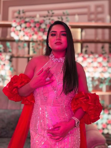 The same gown under dramatic pink lighting, showing how it transforms with the event's ambiance. A versatile outfit is key for a wedding host.