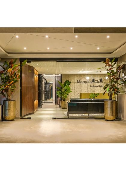 The entrance to the Marquise Clubhouse, designed for Sparkle Realty. We used a neutral material palette, a brass-finished reception desk, and large planters to create a welcoming and luxurious entry point for residents.