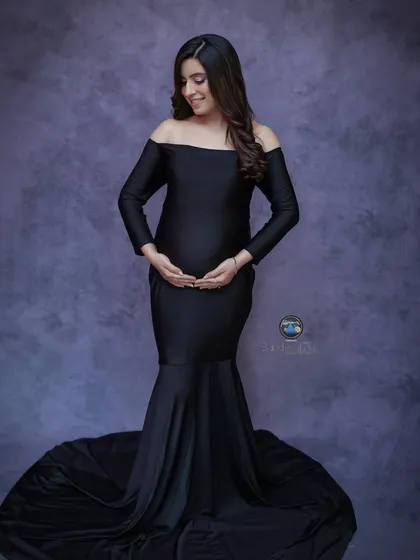 A solo maternity portrait can be incredibly powerful. Here, we used a classic off the shoulder black mermaid gown to create an elegant silhouette, highlighting the beautiful shape of her baby bump against a textured studio backdrop.