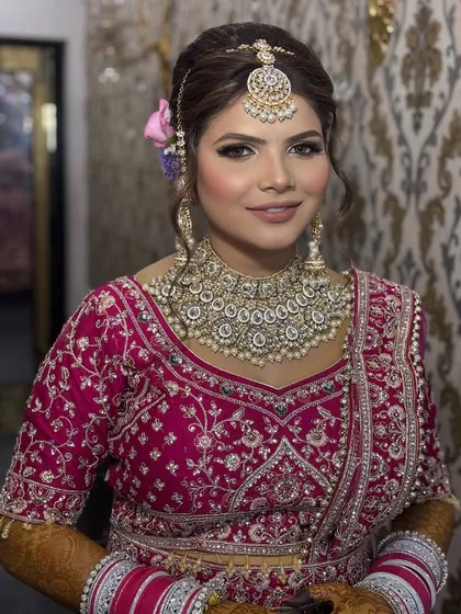A smiling portrait of the bride. Her makeup is fresh and radiant, with a touch of pink on the cheeks and lips to give a youthful and happy glow.
