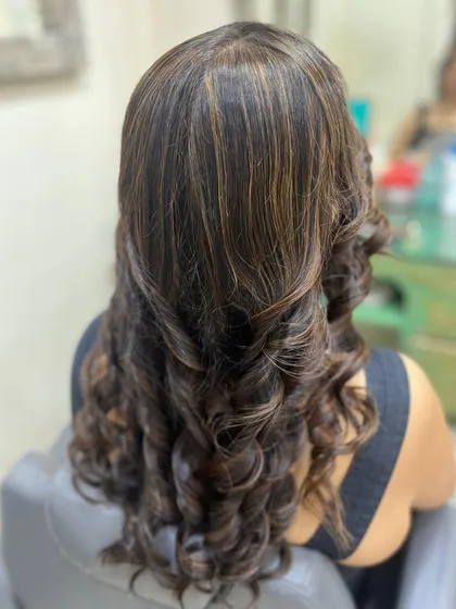 Here, I've added warm, golden highlights to dark hair and styled it with defined, cascading curls. This look is perfect for adding brightness and texture.