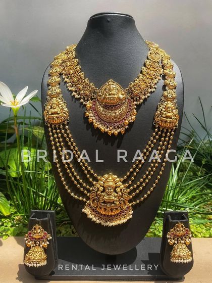 A stunning multi-layered temple necklace set with two prominent Lakshmi pendants. The cascading bead chains add a touch of royalty.