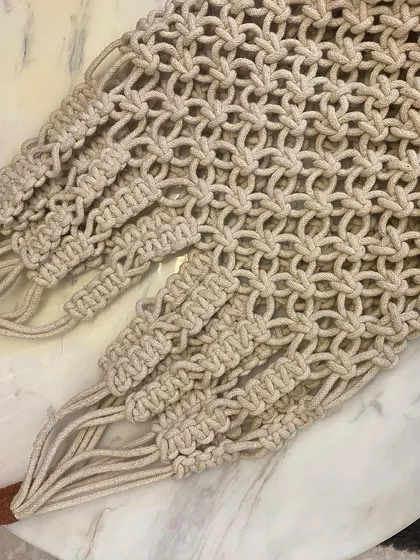 Another close-up of the handles and the top section of the macrame net tote, showing how the straps are securely integrated into the bag's body.