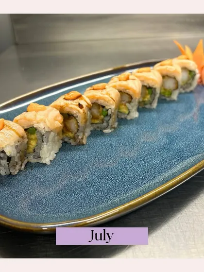 A beautifully plated line of torched salmon sushi rolls from a July event. This close-up highlights the freshness of our ingredients and the artistry of our sushi chefs.