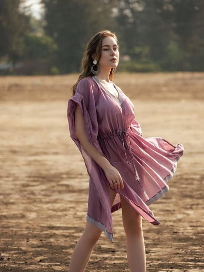 The wind catching the sheer fabric of the kaftan creates a beautiful sense of movement and grace in this shot.