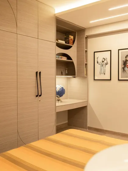 We designed this teenager's bedroom with a calm and subtle palette. The light wood tones of the integrated wardrobe and study desk create a serene atmosphere, while the striped bedding adds a touch of youthful energy.