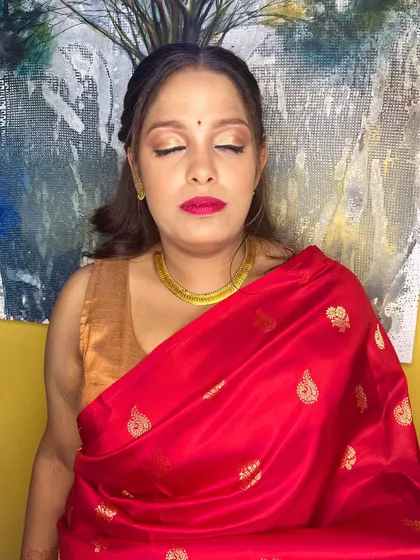 A traditional look with a modern twist. The makeup features a classic red lip and winged liner, paired with a contemporary braided hairstyle.