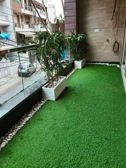 A simple yet effective balcony makeover. We installed high-quality artificial grass and added white planters with bamboo for a clean, green look.