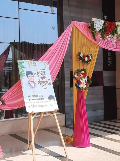 A welcome easel with a personalized sign for the couple, placed next to a beautifully draped entrance at the Green World venue.
