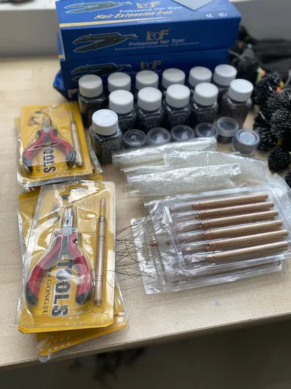 We are a one-stop shop for salon professionals. This image showcases our complete hair extension tool kits, including pliers, needles, micro beads, and keratin glue grains, available for bulk orders.