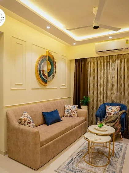 A cozy corner of a living room, featuring a comfortable sofa-bed, a nesting coffee table, and a striking piece of wall art.