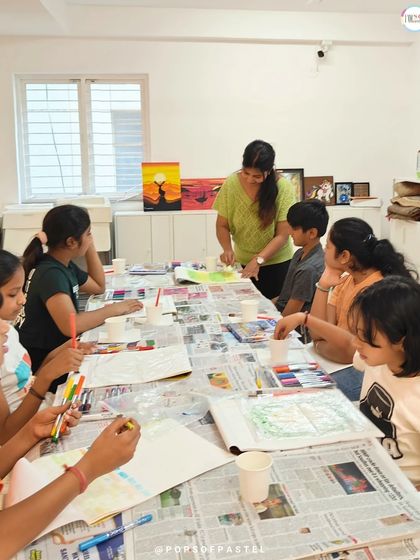 An instructor guides a group of children during a brush lettering workshop, providing personalized attention in a small group setting.