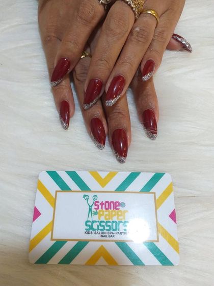 A deep, vampy red polish on long stiletto nails. I added a silver glitter gradient to the tips for a touch of sparkle and a festive feel.