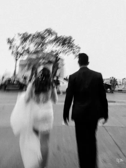 A black and white motion-blur photo of a couple walking down a city street. This artistic technique conveys a sense of movement and the feeling of being in their own world amidst the bustling city.