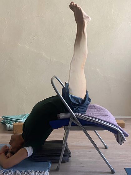 A supported inversion on a chair.