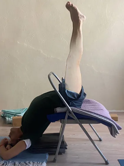 A supported inversion on a chair.