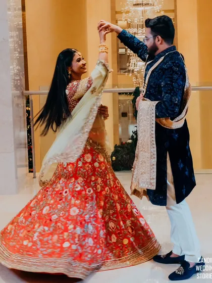 A beautiful dance pose, capturing the bride's flowing lehenga and the couple's graceful movement during their reception entry.