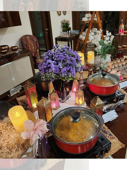 An intimate and cozy buffet setup for a house party. The warm lighting from the lanterns and candles creates a welcoming atmosphere for guests.