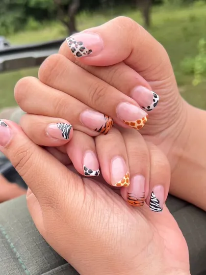 This set shows my skill with detailed, custom nail art, featuring different animal prints like leopard, giraffe, and zebra on each nail in a creative French tip style.
