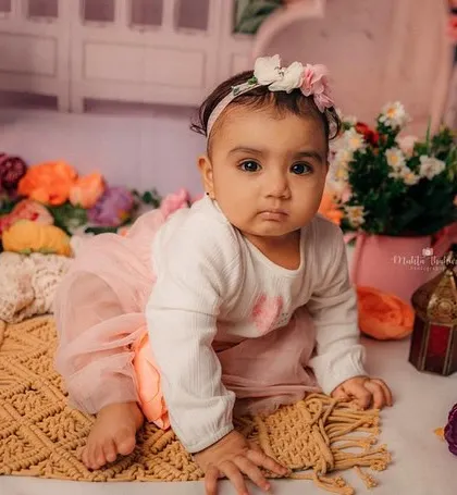 Crawling through a field of flowers. This shot captures her mobility and curiosity at eight months old.