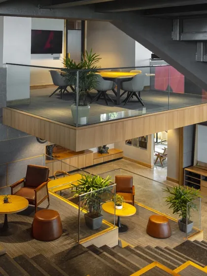 This high-angle shot of the Primarc office highlights the various zones for work and relaxation. The design integrates meeting pods, lounge areas, and informal seating, giving employees the flexibility to choose how and where they work.