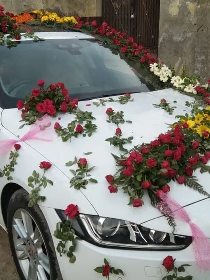 This white Jaguar features a simple yet elegant decoration. I used scattered red roses and small bouquets with pink ribbons to create a delicate and romantic design.