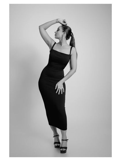 A dynamic pose that shows off the model's confidence and the classic silhouette of the dress.