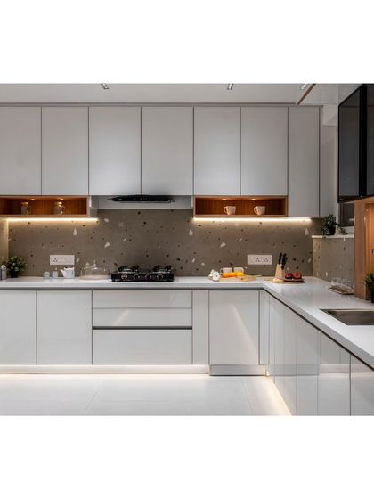 The kitchen is designed to be both beautiful and highly functional. We used a terrazzo-style backsplash, sleek white cabinets, and warm wood niches to create a clean look with plenty of storage.