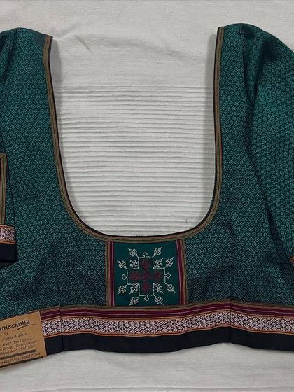 A ready-made blouse made from 'Khun' fabric, with Kasuti embroidered patches on the sleeves and front. This design pays homage to the traditional textiles of Karnataka.