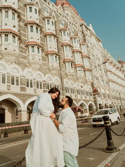 A grand, romantic pose in front of the iconic Taj Mahal Palace Hotel in Mumbai. This location provides a timeless and elegant backdrop for a classic pre-wedding shoot.