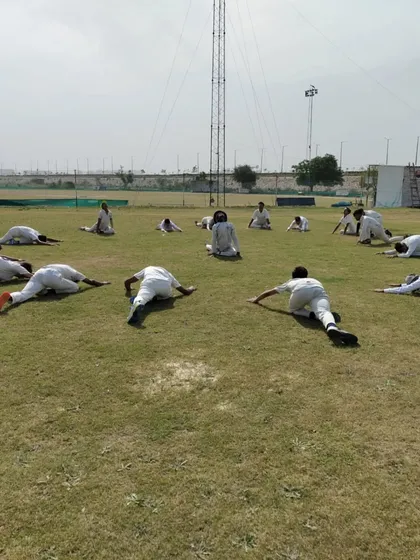 Cool-downs and flexibility are just as important as the main workout. Here, players are performing essential stretches to aid muscle recovery and improve their range of motion for better performance.