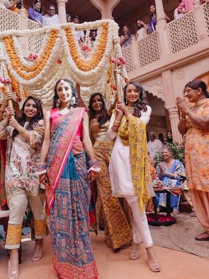 The bride's grand entrance under a floral canopy held by her bridesmaids was a highlight of the Phulkari-themed Haldi ceremony.