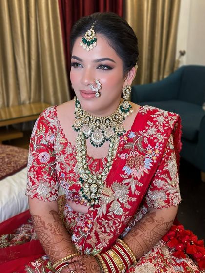A regal look for a regal bride. Vibhuti's makeup featured a sharp, winged liner and a bold lip to match the grandeur of her heavily embroidered red and green lehenga.