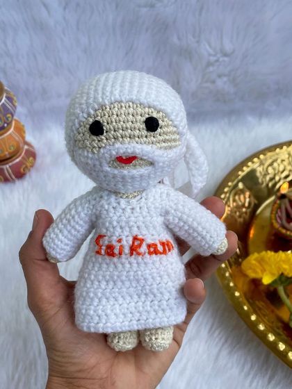 A serene doll of Sai Baba, dressed in all white with "Sai Ram" embroidered on his robe. These dolls bring a sense of peace and make a thoughtful gift for devotees.