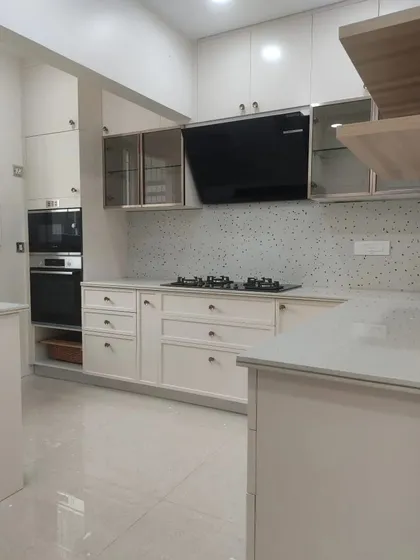 A wide shot of the completed kitchen, showing the L-shaped layout, ample storage, and bright, overhead lighting.