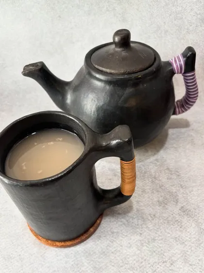 Our homemade fermented rice drink, Zutho, served in traditional Longpi pottery. This black pottery is handcrafted by artisans in Manipur from a special blend of stone and clay. Every sip is a taste of our heritage, connecting you to the ancient crafts of our people.