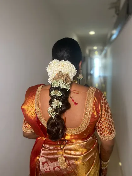 A back view of the floral messy braid, showing the rich texture and volume.