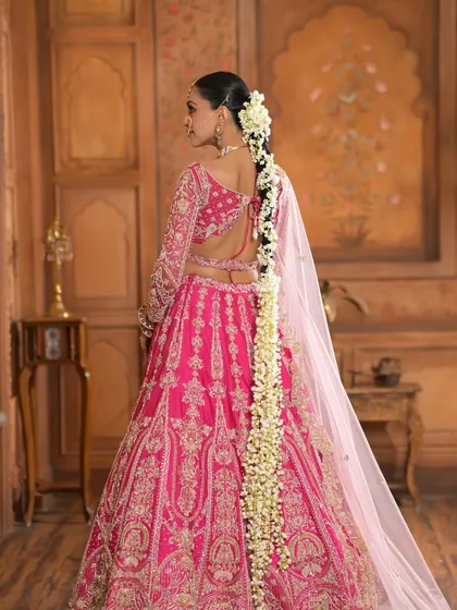 Another view from the back, capturing the full length of the stunning floral braid and the flow of the beautiful pink lehenga.
