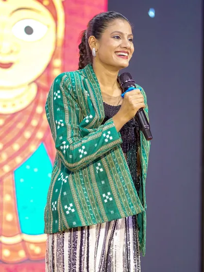 Addressing the audience at an Utkal Divas event. I often share stories about my heritage and the meaning behind the folk dance styles I perform.