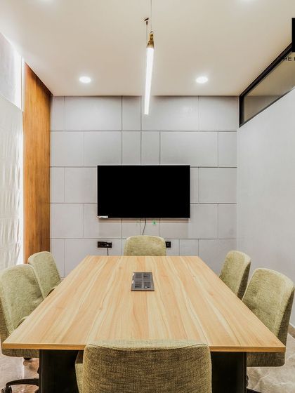 A view of the sleek, modern conference room in the Embassy office. The room is equipped with integrated technology and features wood-paneled and textured walls, creating a professional setting for meetings.