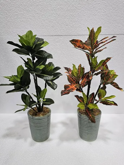 Two medium-sized artificial plants in grey ceramic pots, showcasing different leaf shapes and colors.