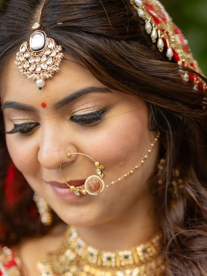 A detailed shot of the eye makeup and traditional nath. The look is elegant and understated, perfect for a bride who wants a minimal look.