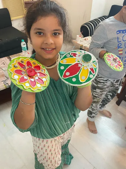A very happy participant showing off the two beautiful Lippan art tea light holders she painted. It’s so rewarding to see kids proud of the festive decor they created themselves.