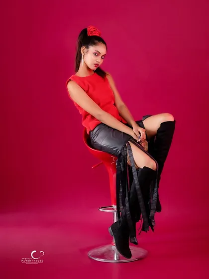 A relaxed yet stylish seated pose. Her direct gaze is engaging, and the composition is beautifully balanced.